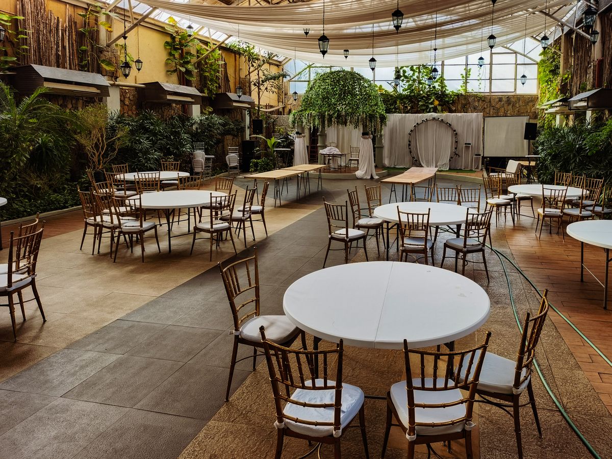 Empty indoor wedding reception venue set with round tables and chairs