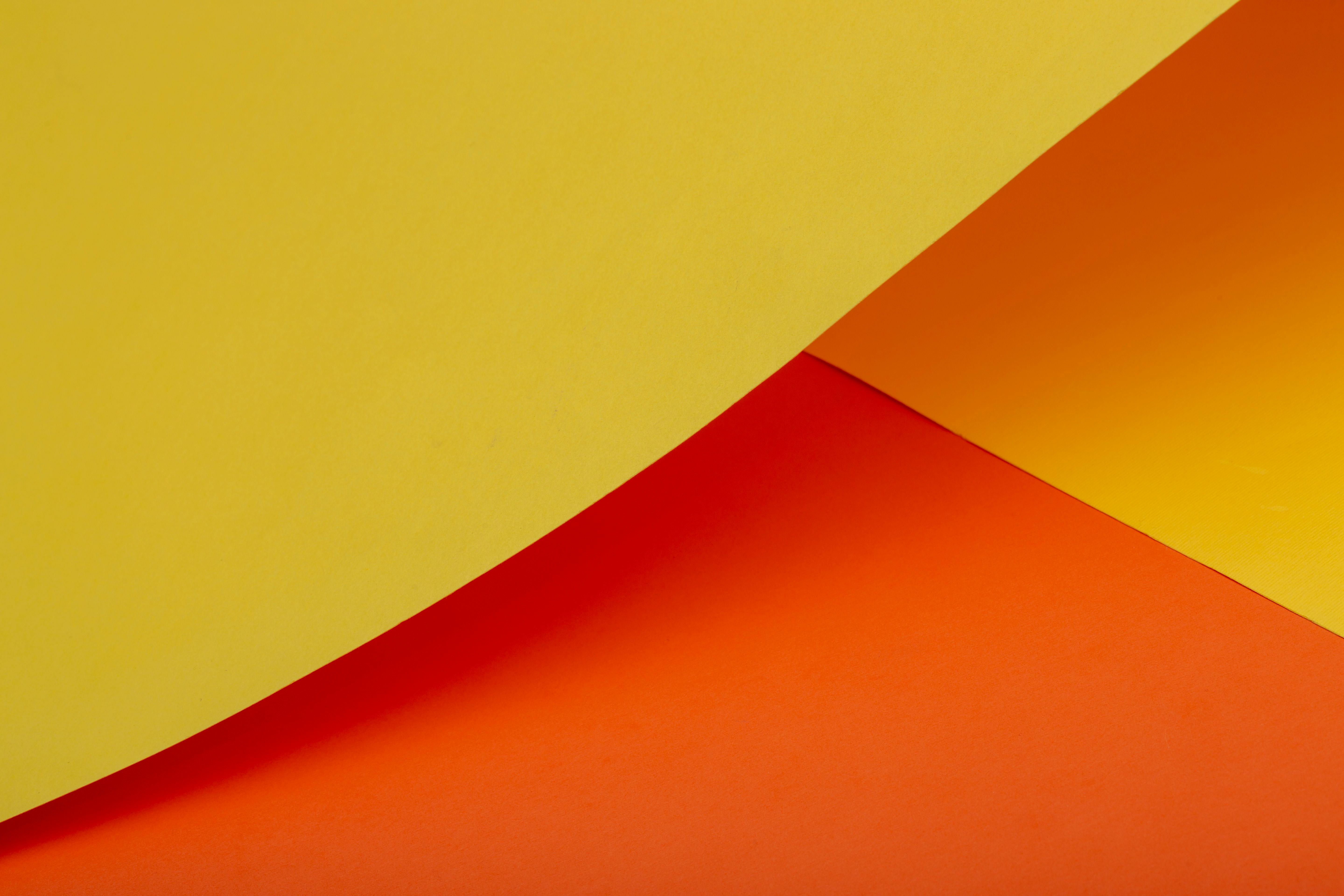 Free A vibrant abstract composition featuring curved yellow and orange paper, ideal for creative backgrounds. Stock Photo