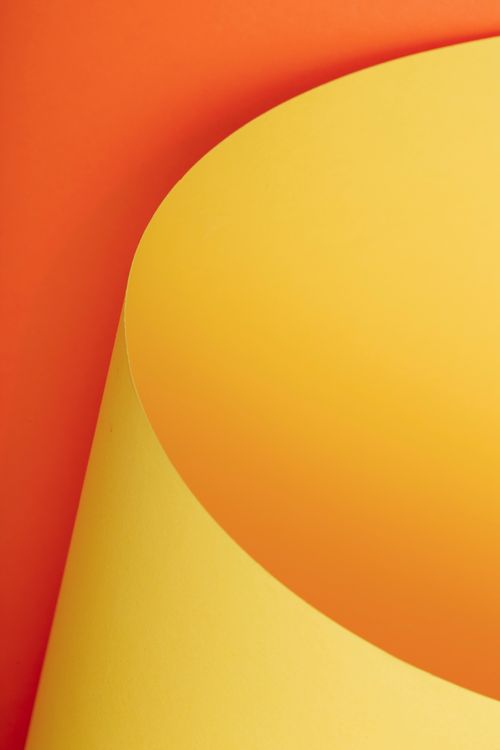 Free Creative abstract art featuring curved yellow and orange paper. Ideal for modern designs. Stock Photo
