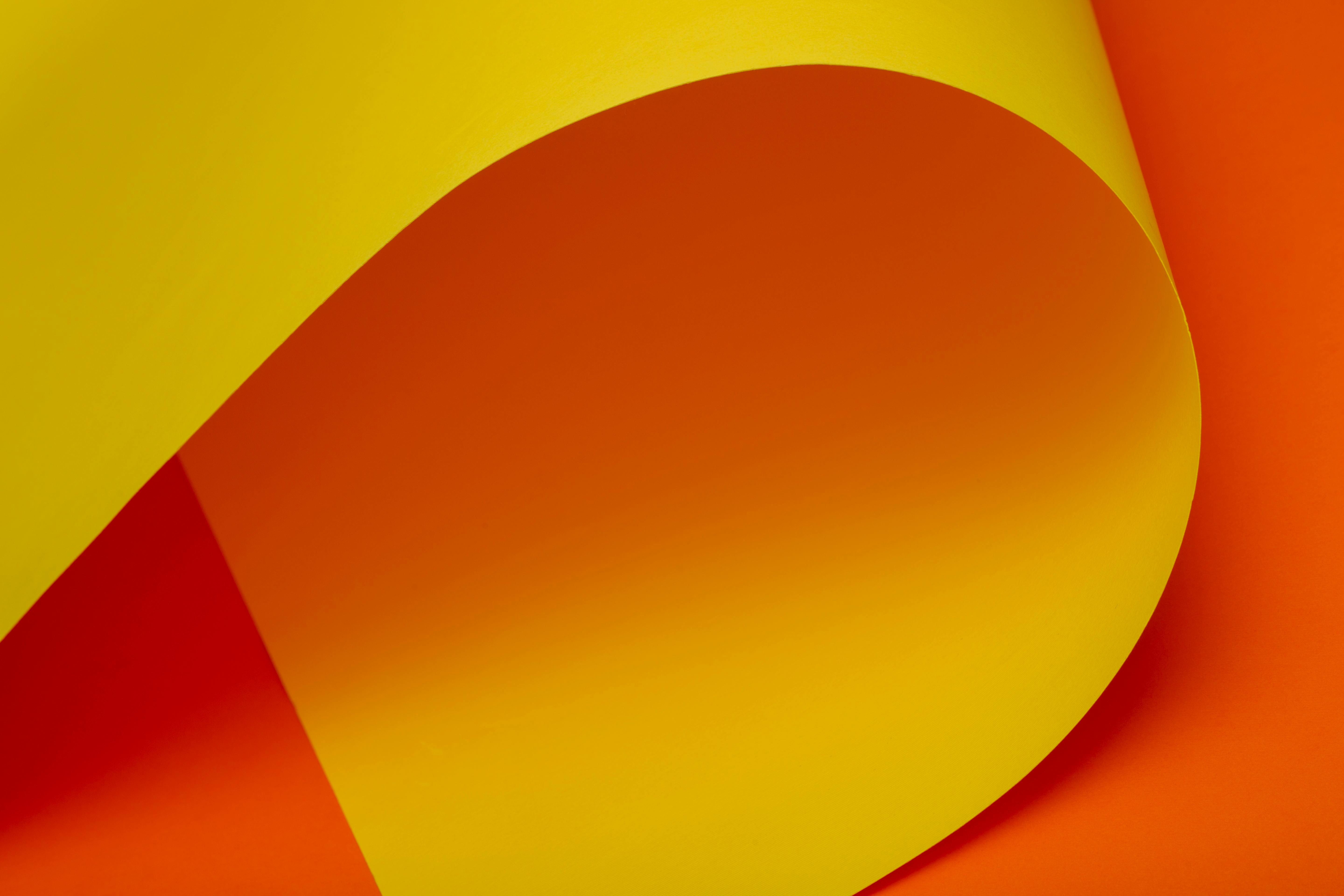 Ücretsiz Canlı sarı ve turuncu kavisli kağıt desenine sahip yaratıcı bir soyut görsel. Stok Fotoğraflar