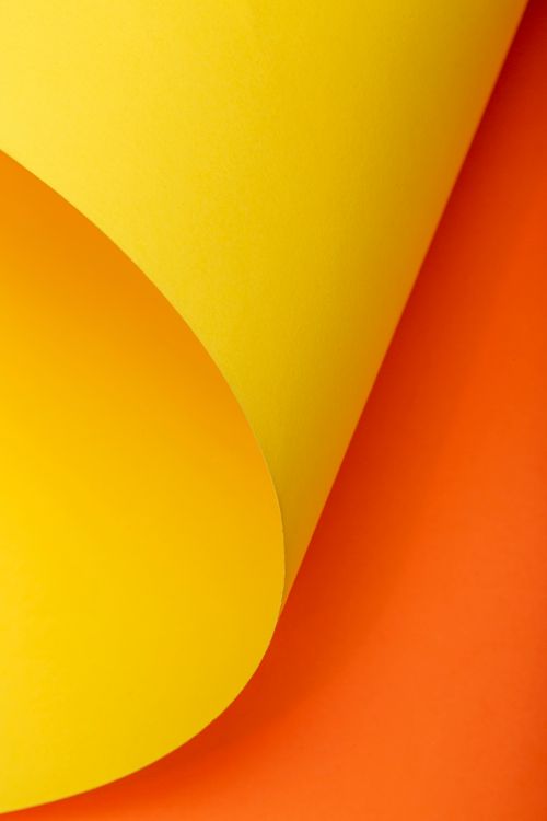 Free Bright yellow and orange paper creates a striking abstract composition, full of color and texture. Stock Photo