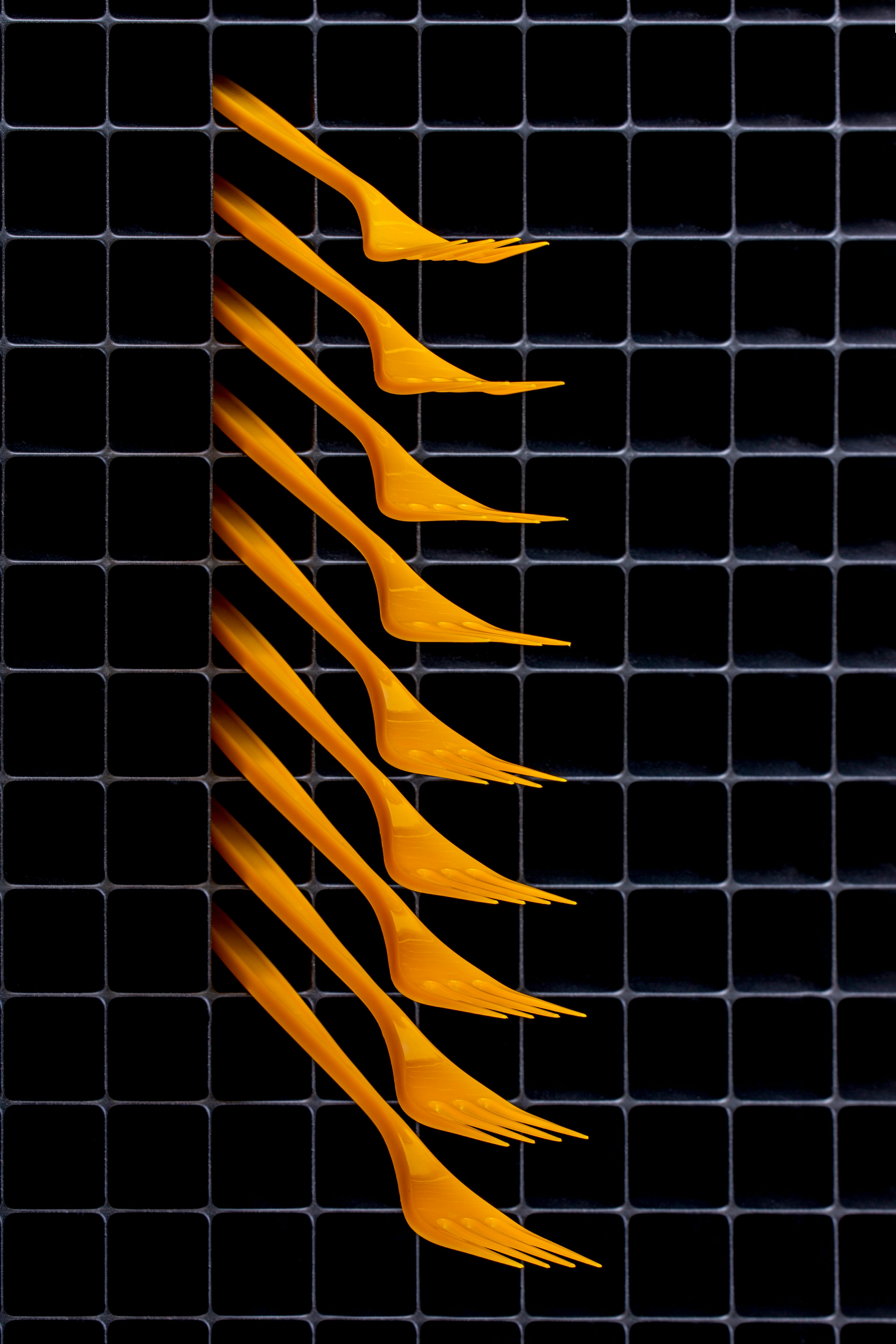 gratis Creatieve schikking van gele vorken in een rasterpatroon, waarmee abstracte kunst en hedendaags design worden getoond. Stockfoto