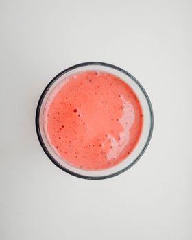 俯视玻璃杯中充满活力的粉红色草莓冰沙，非常适合作为清凉饮料