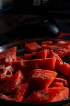 Detailed shot of freshly sliced watermelon with seeds on a plate, showcasing vibrant red color.