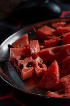 Juicy watermelon slices on a metallic plate, perfect for refreshing summertime snacking.