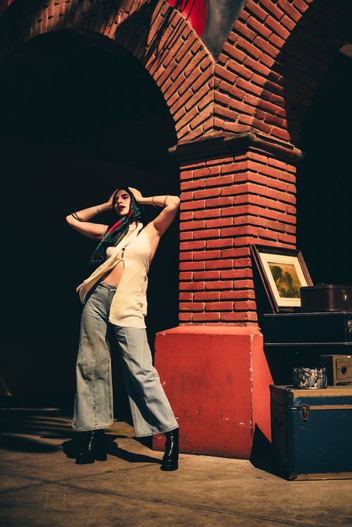 Free Fashionable woman poses in a brick archway setting, exuding confidence and style. Stock Photo