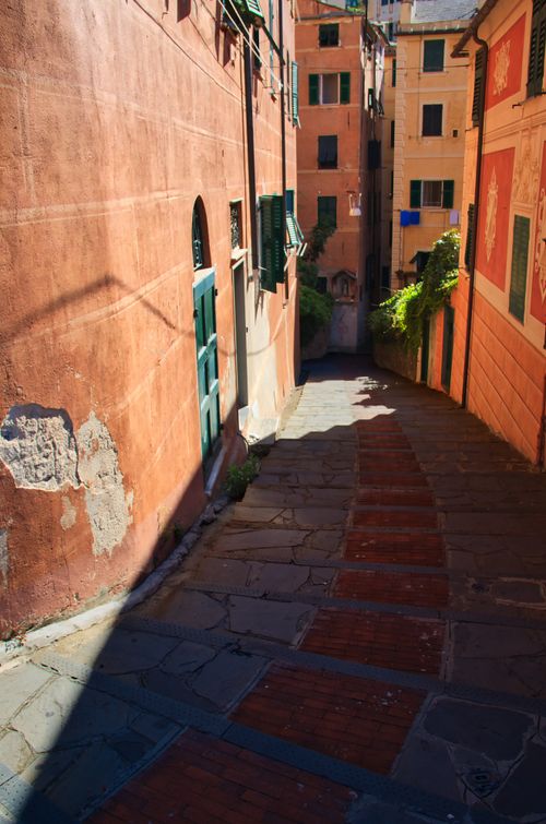 Free Sunlit narrow alley in Camogli, Italy, showcasing colorful historic architecture. Stock Photo