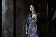 Elegant Woman Holding White Lotus in Traditional Attire
