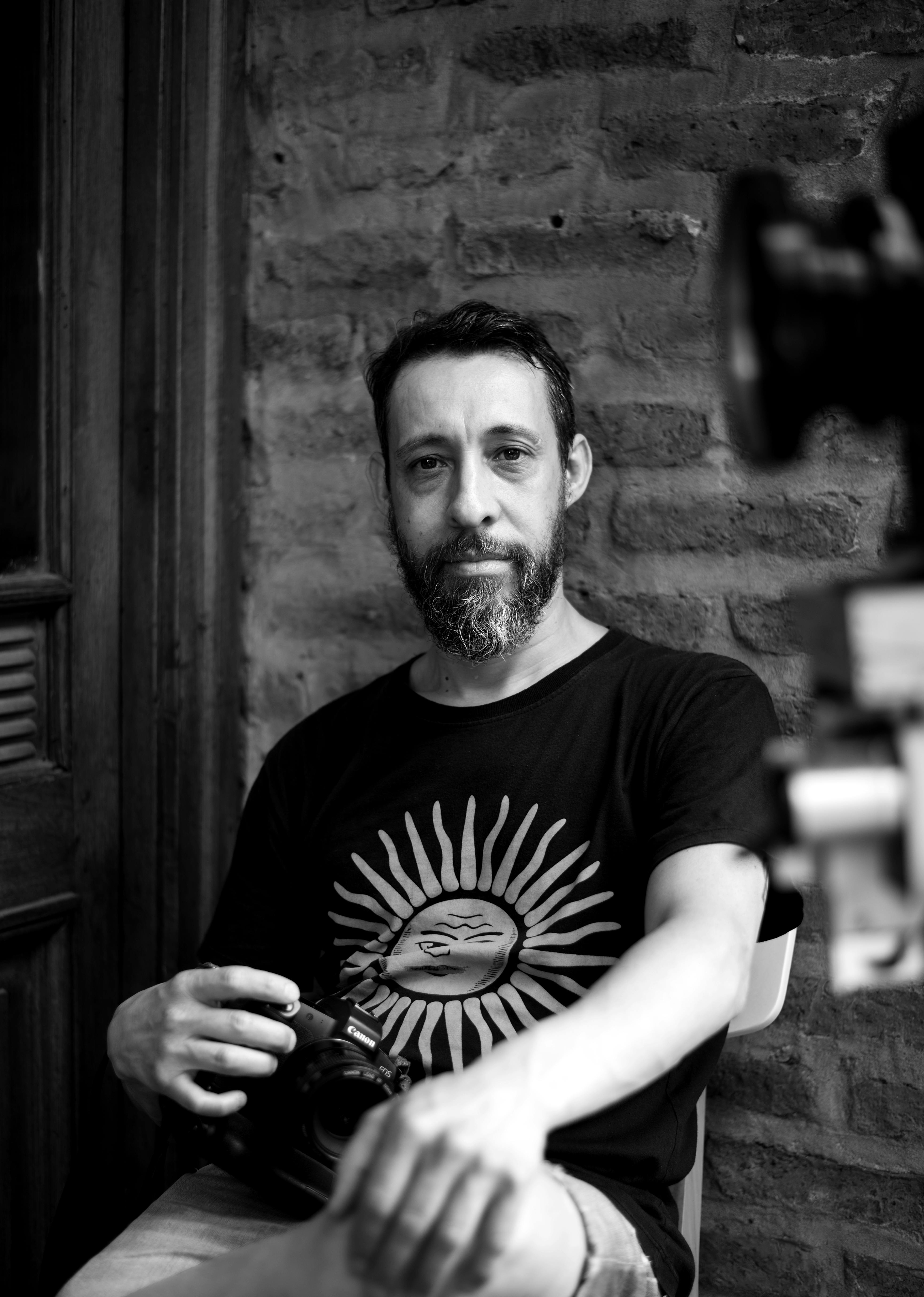 Black and white portrait of a man in Buenos Aires, Argentina, with a relaxed pose.