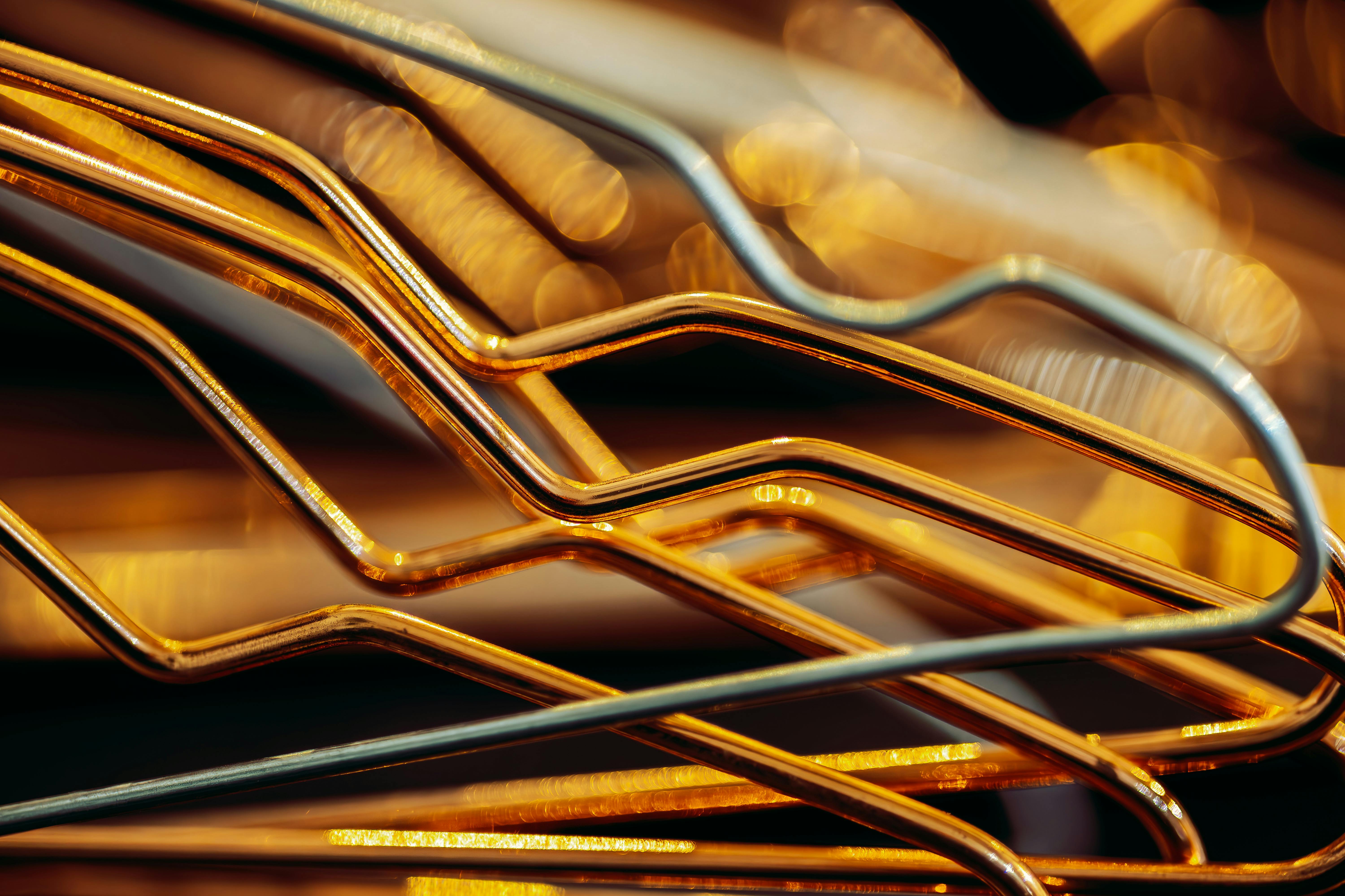 Gratis Primer plano de formas abstractas metálicas doradas que crean un patrón geométrico con efecto bokeh en el fondo. Foto de stock