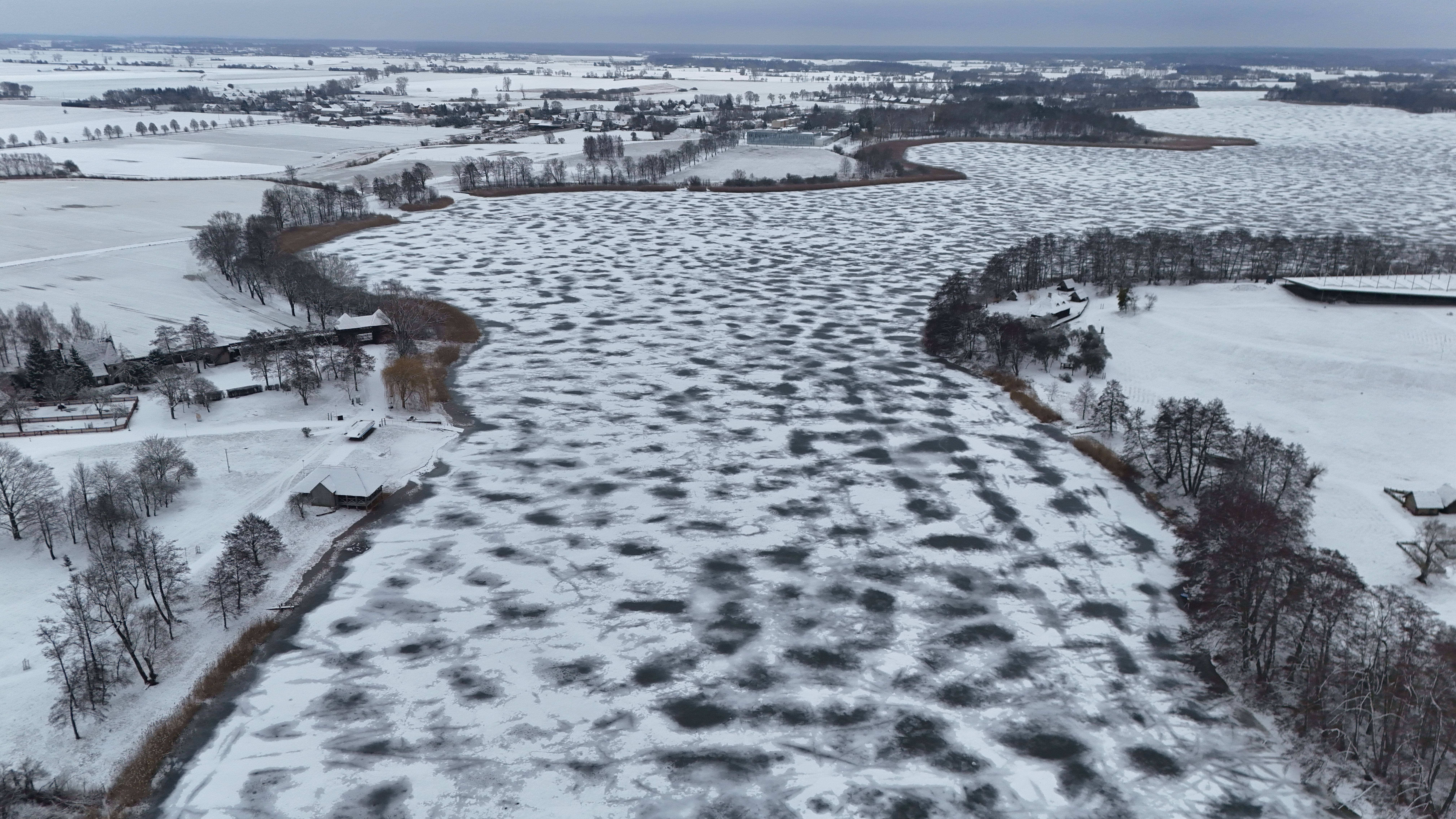 Aerial view of a snowy and frozen river landscape in Poland during winter. — Trójmiasto