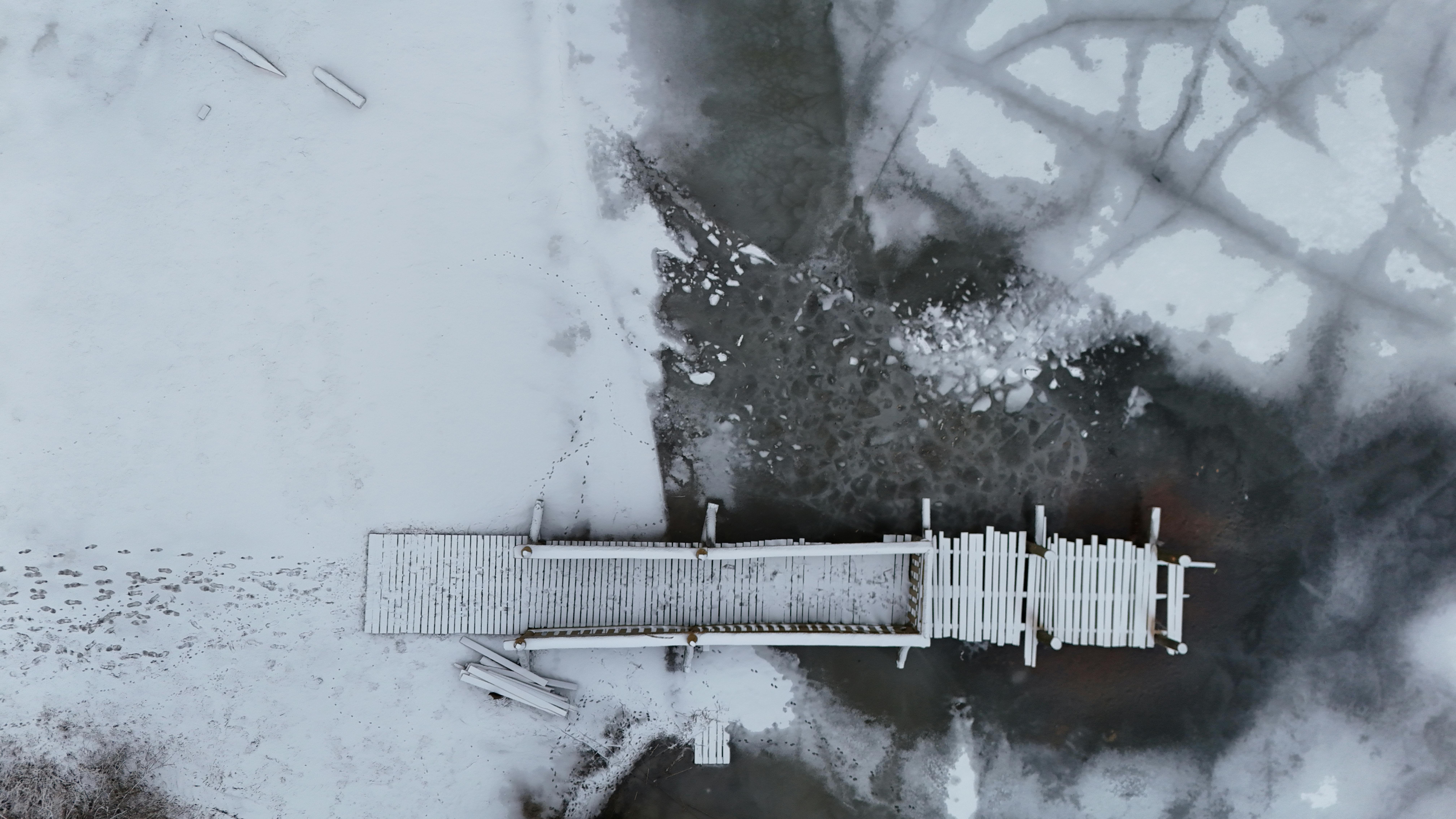 gratis Luchtfoto van een met sneeuw bedekte pier boven een bevroren meer in een vredig winterlandschap. Stockfoto