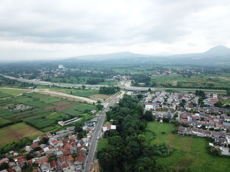 Scenic aerial view of lush green landscape, residential areas, and roadways in West Java, Indonesia. - Fotografer Sidoarjo