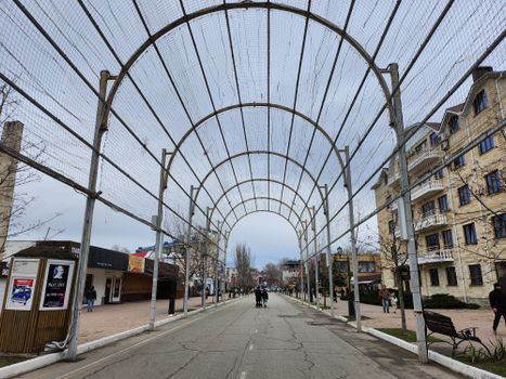 A wide-angle view of a city street with a metal canopy, capturing urban architecture.