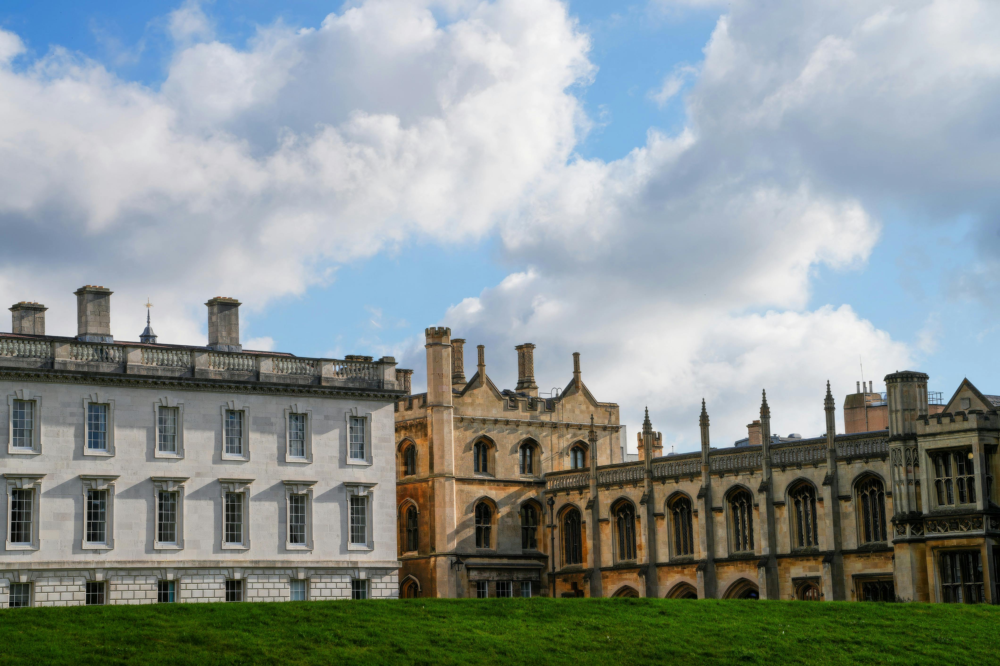View of historic university architecture in Cambridge under a bright blue sky.