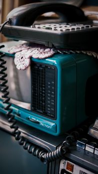 Close-up of a retro radio and telephone on a shelf, evoking nostalgia.