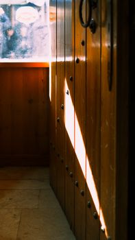 Sunlight streaming through a window, creating artistic shadows on wooden walls.