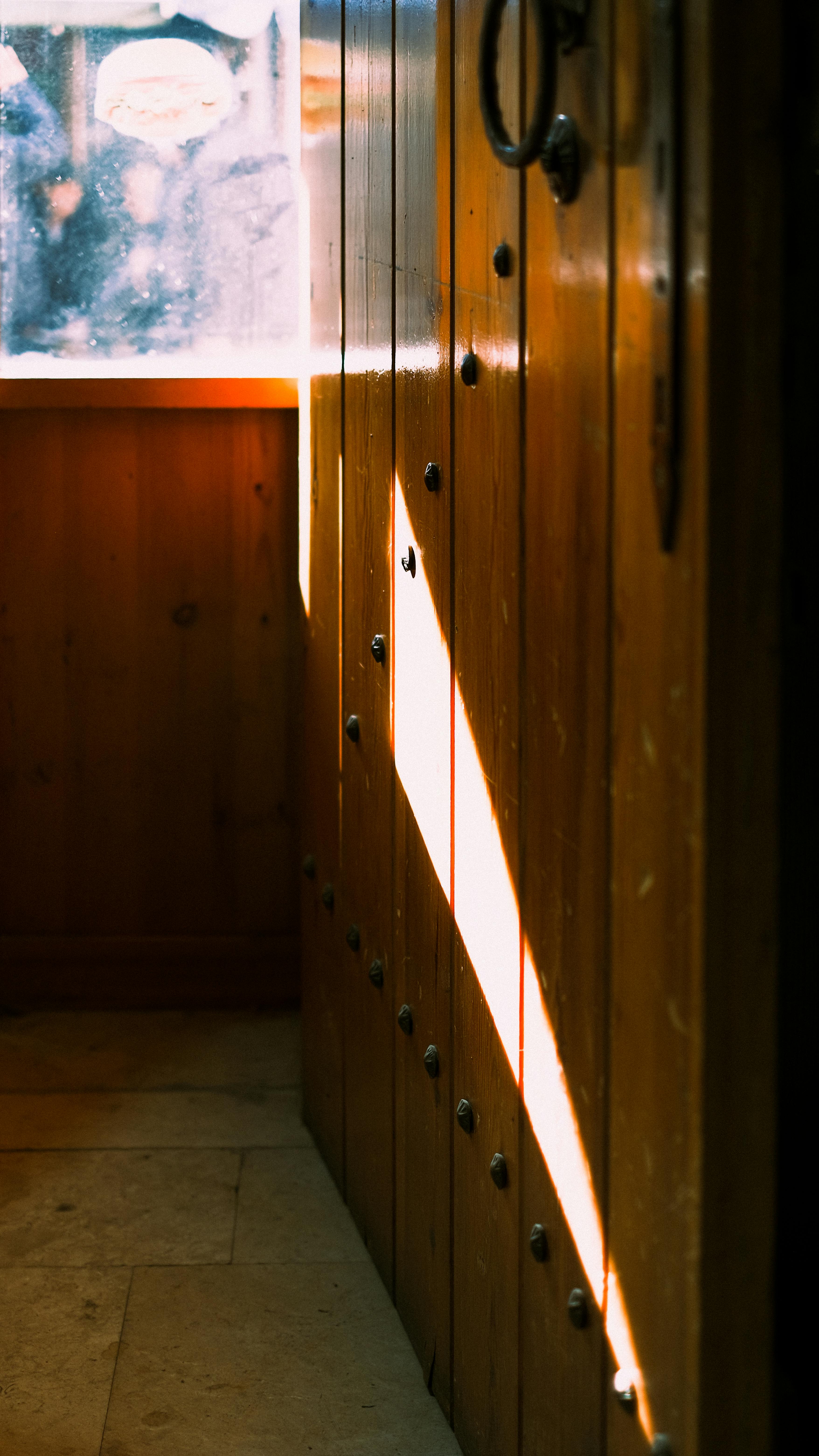 gratis Zonlicht dat door een raam naar binnen stroomt, werpt artistieke schaduwen op de houten muren. Stockfoto