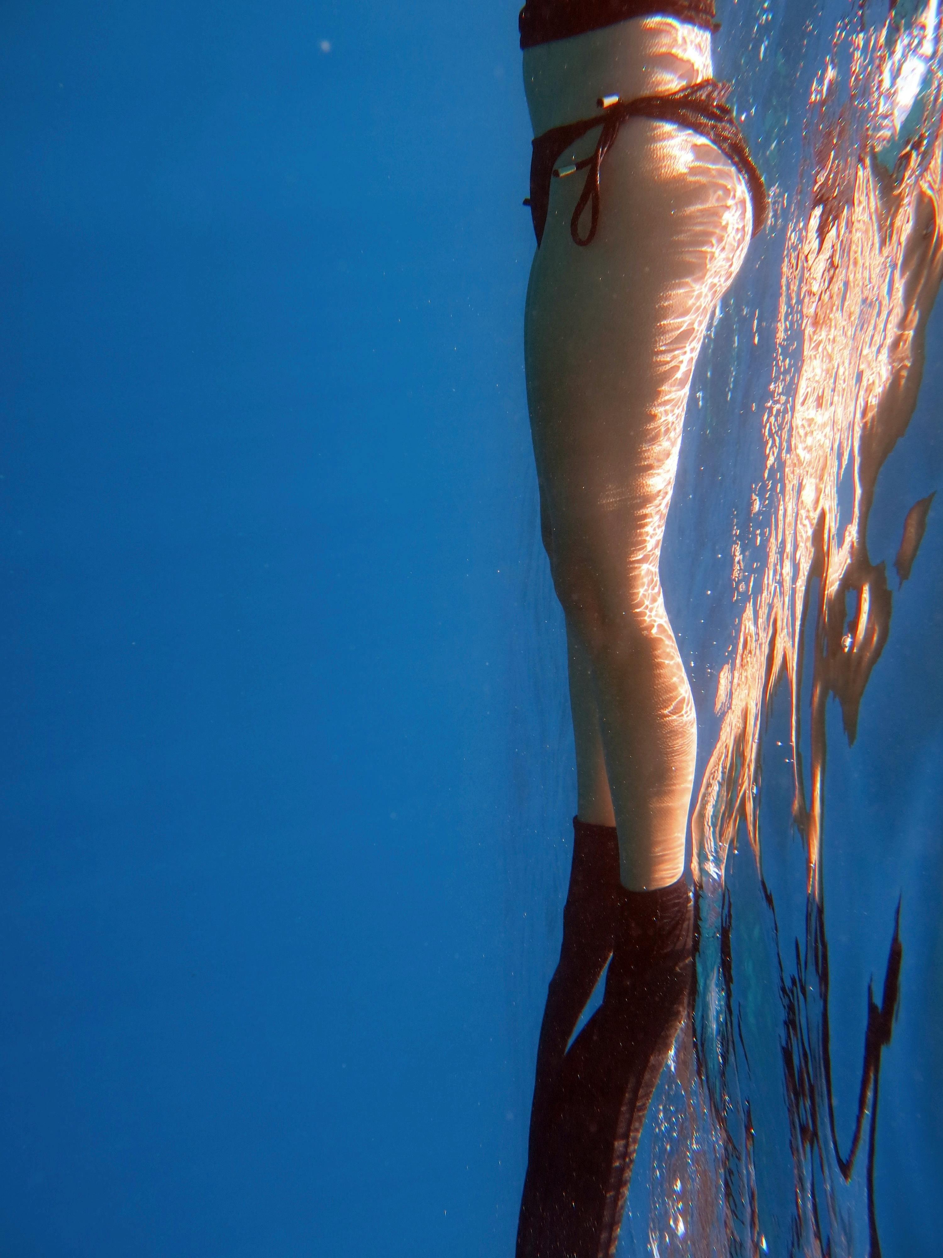 Artistic underwater photo of a swimmer in Bodrum, Türkiye, with a water reflection.