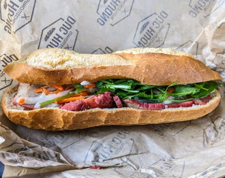 Delicious Vietnamese banh mi sandwich filled with fresh ingredients on rustic paper.