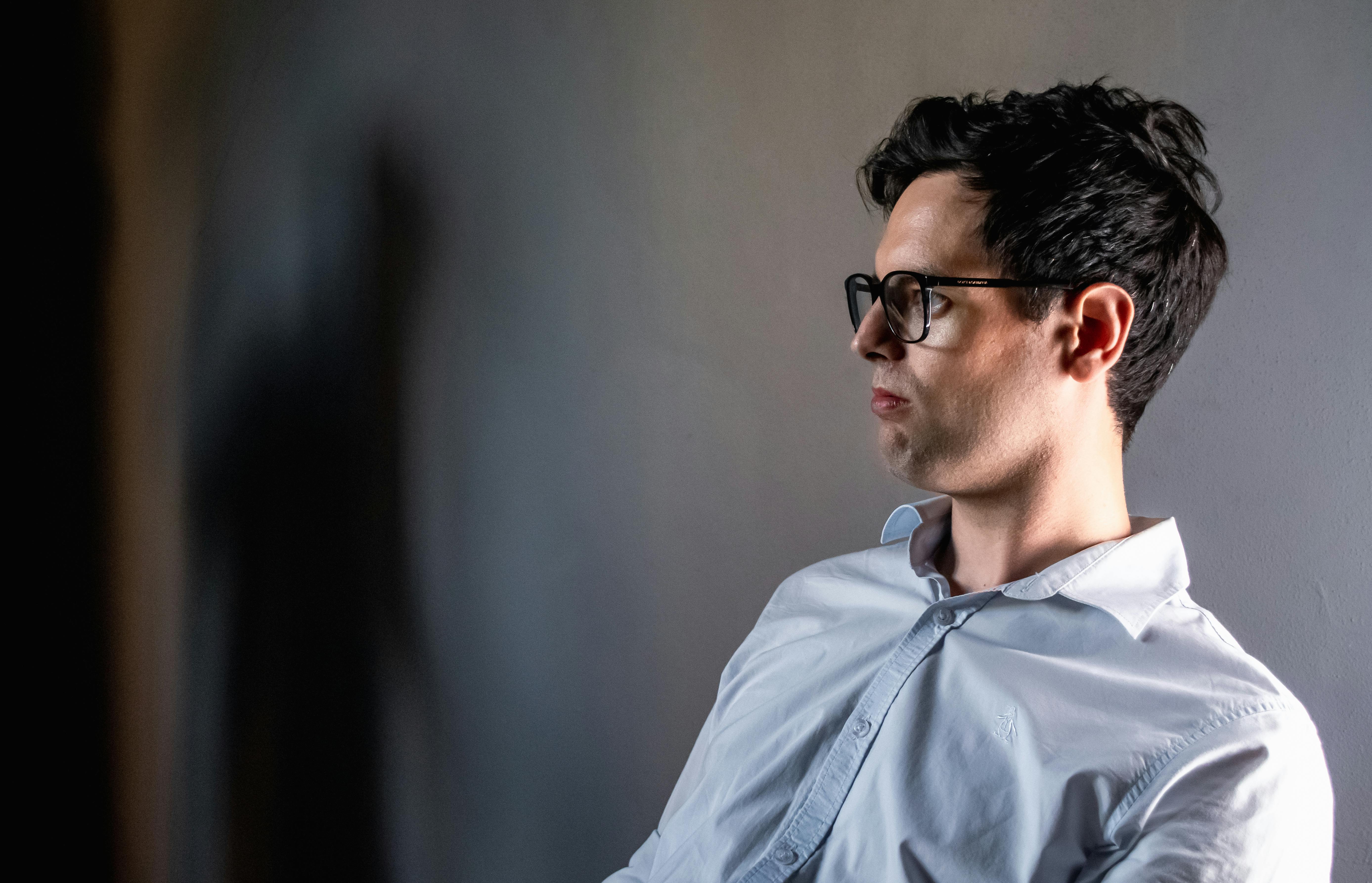 ฟรี ภาพด้านข้างของชายสวมแว่นตา ท่ามกลางฉากหลังที่ดูหม่นหมอง มีเงาปรากฏให้เห็น คลังภาพถ่าย