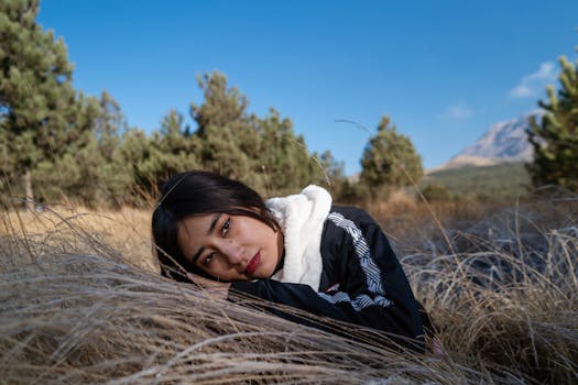 Peaceful portrait of a young woman resting in a picturesque mountain landscape.