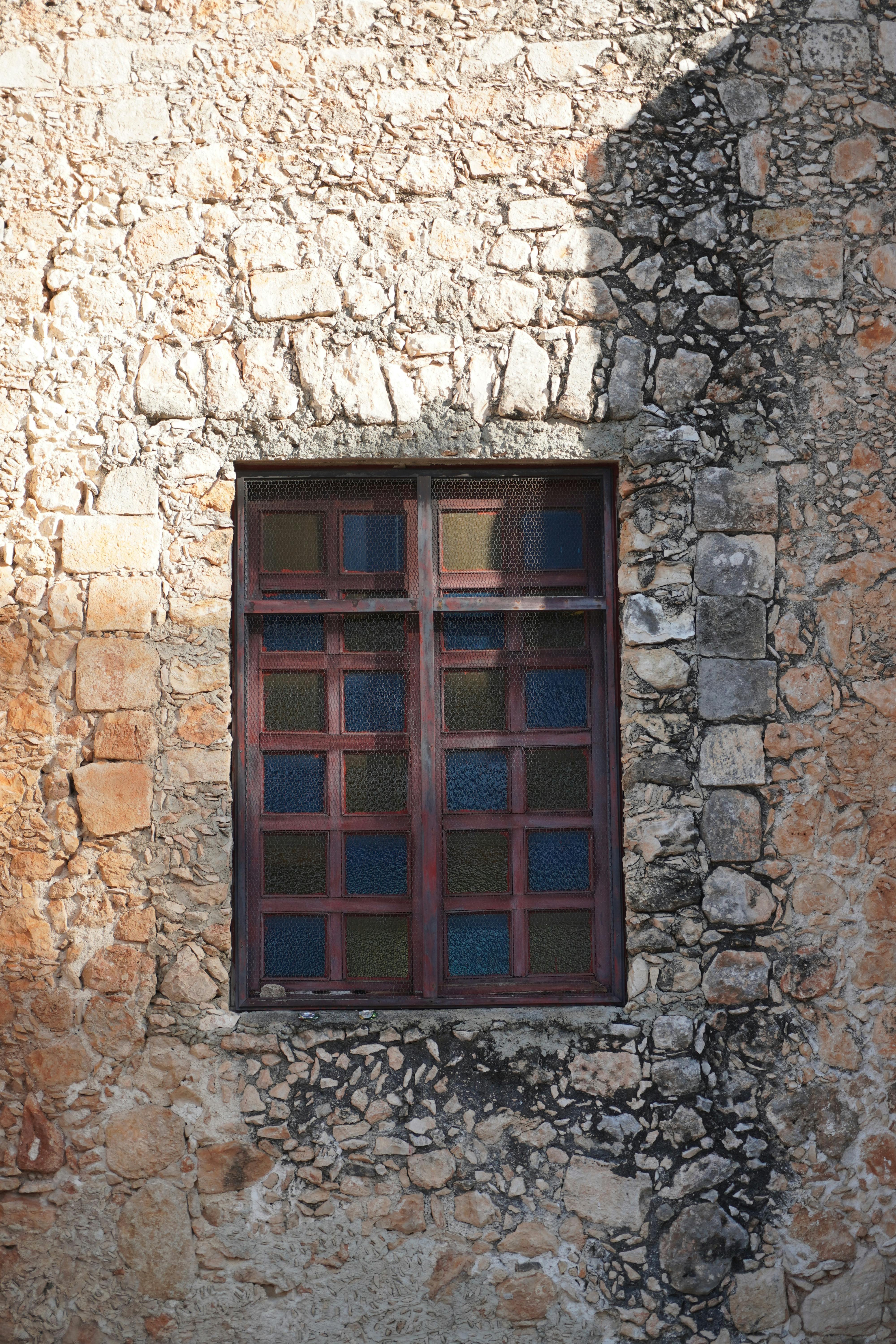 Gratis Una storica finestra in legno incastonata in un rustico muro di pietra, che mette in mostra l'architettura coloniale dello Yucatán. Foto a disposizione