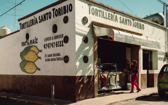 A woman stands outside Tortillería Santo Toribio, a traditional Mexican tortilla shop.