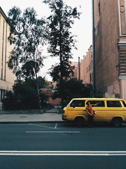 Person Standing Near Yellow Van on Road