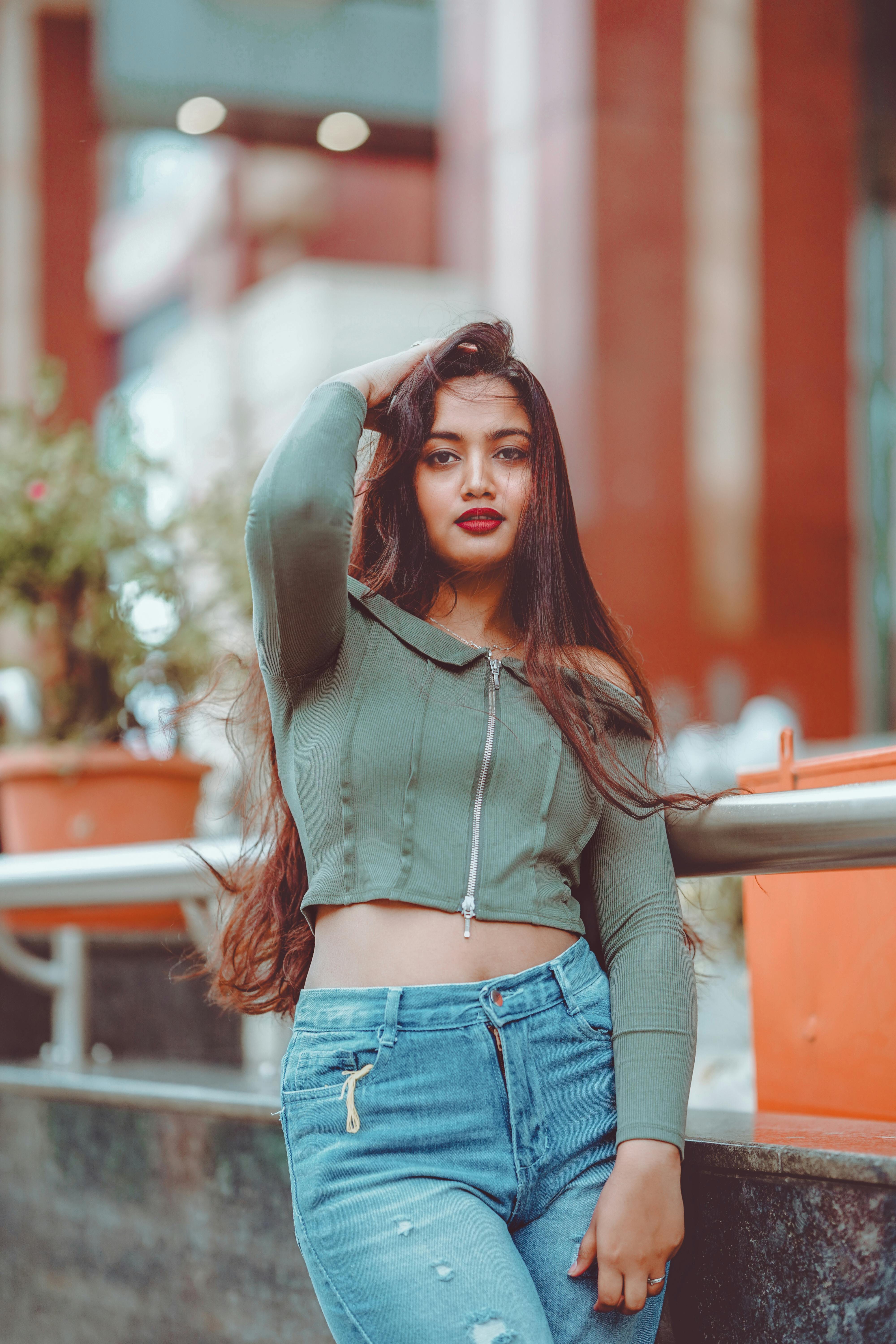 ฟรี หญิงสาวในชุดลำลองโพสท่าอย่างมั่นใจกลางแจ้ง บรรยากาศชีวิตในเมืองที่คึกคัก คลังภาพถ่าย