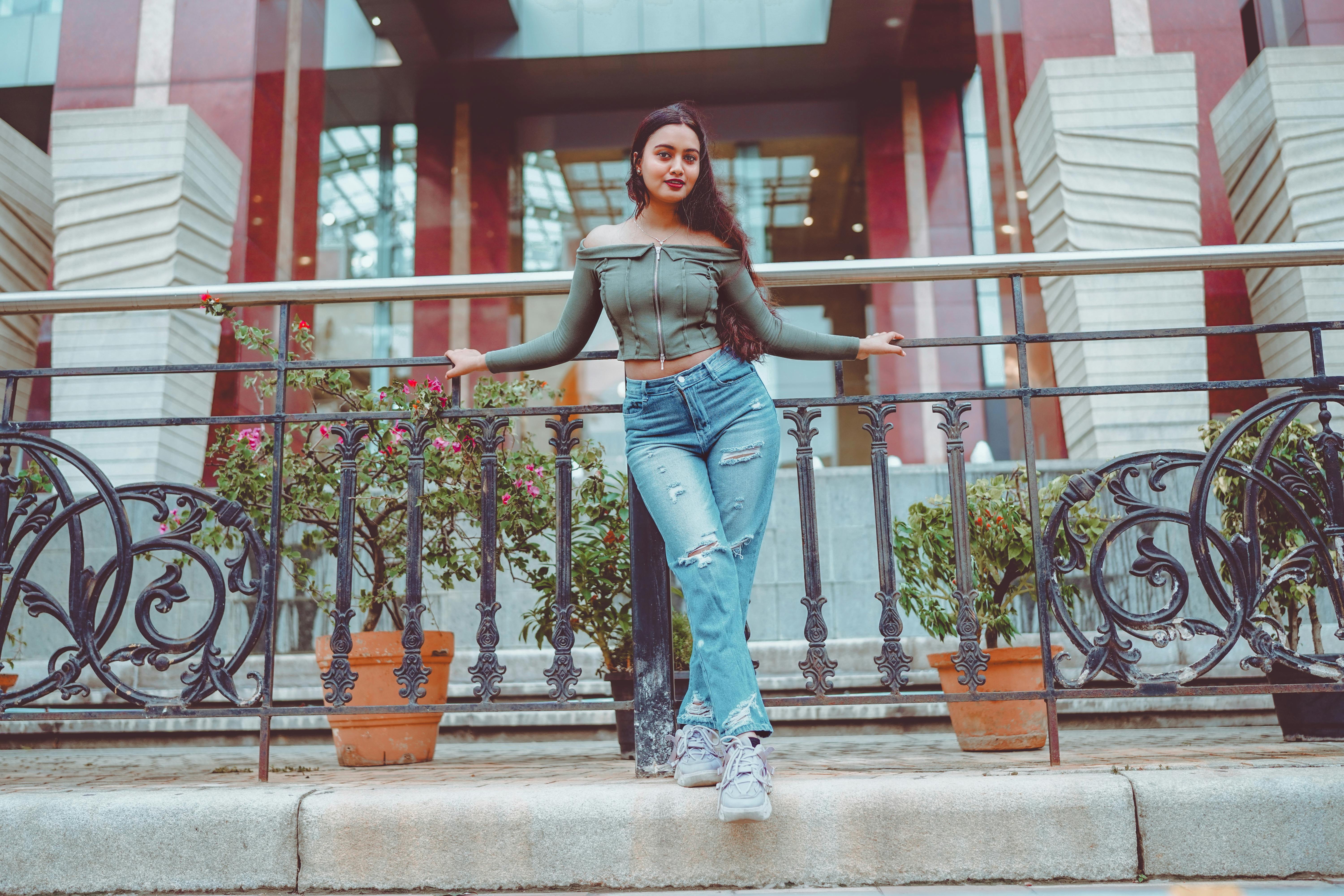 ฟรี หญิงสาวมีสไตล์ในชุดทันสมัย ​​โพสท่ากลางแจ้งโดยมีฉากหลังเป็นสถาปัตยกรรม คลังภาพถ่าย