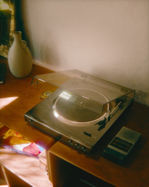 Free A cozy retro setup featuring a vinyl turntable, cassette player, and warm lighting. Stock Photo