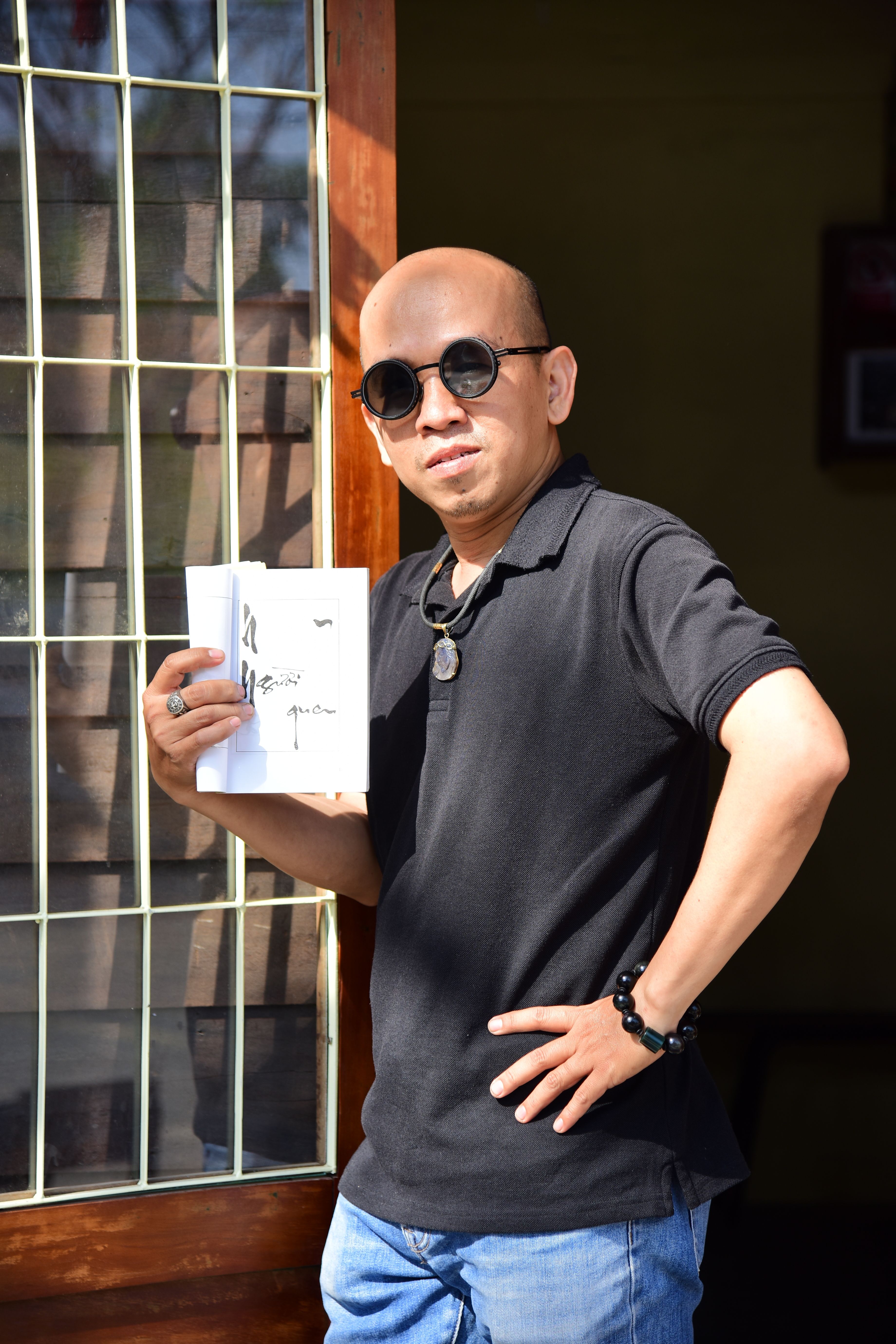 Casual Portrait of Man with Sunglasses Holding Book