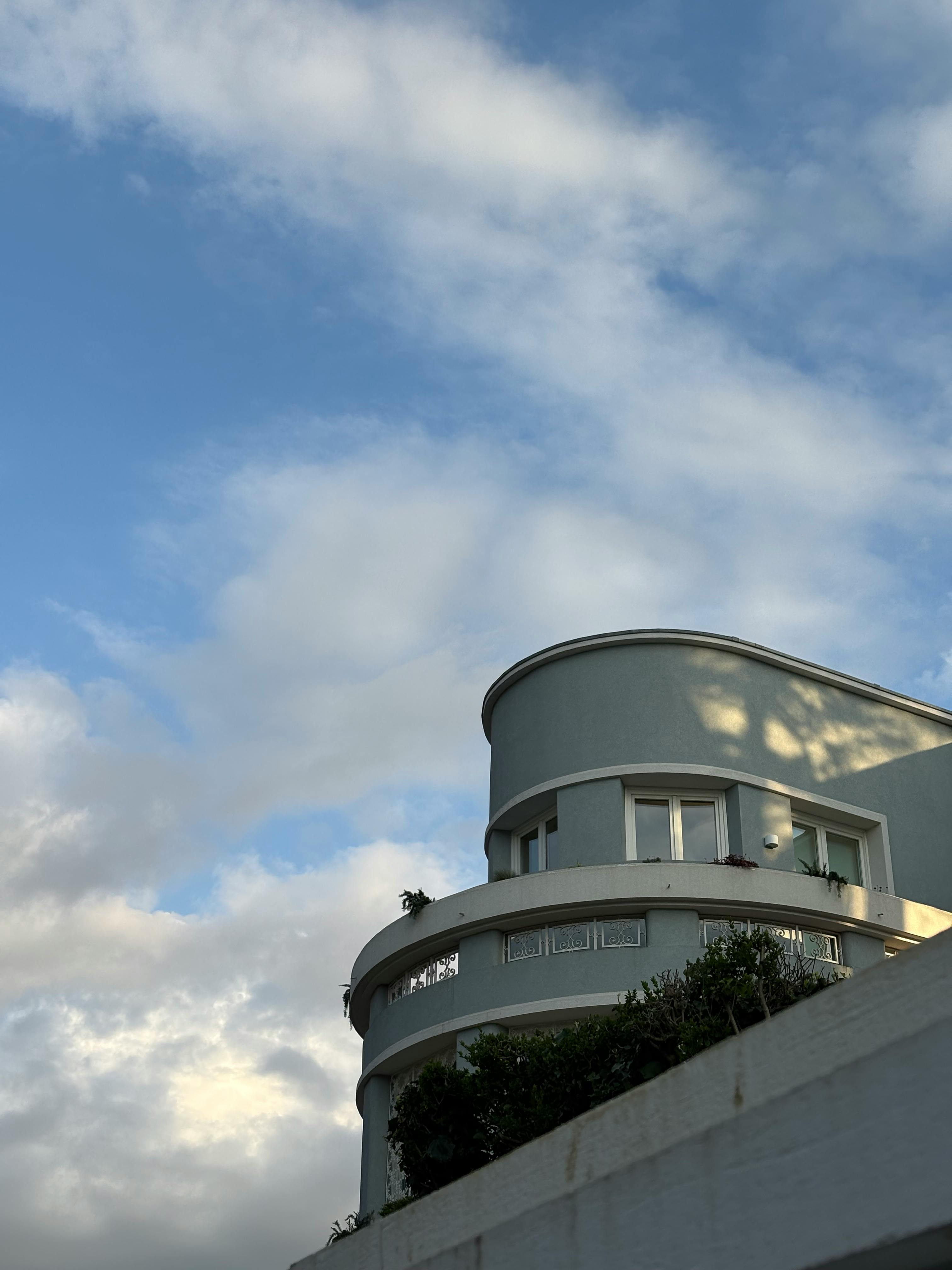 gratis Gebogen modern gebouw in Porto, Portugal, met een bewolkte blauwe lucht op de achtergrond. Buiten gefotografeerd in een rustige omgeving. Stockfoto