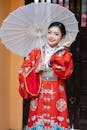 Woman in Traditional Red Hanfu Posing with Umbrella