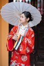 Elegant Woman in Traditional Asian Attire with Umbrella