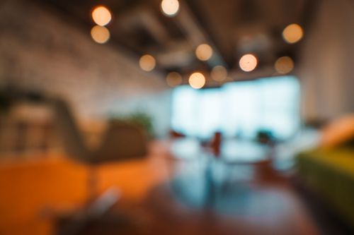 Free Blurred view of a modern office space with warm lighting and stylish interior design featuring bokeh effect. Stock Photo