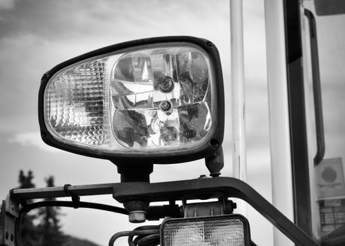 Free A black and white photograph of a vehicle headlight showcasing intricate details and reflections. Stock Photo