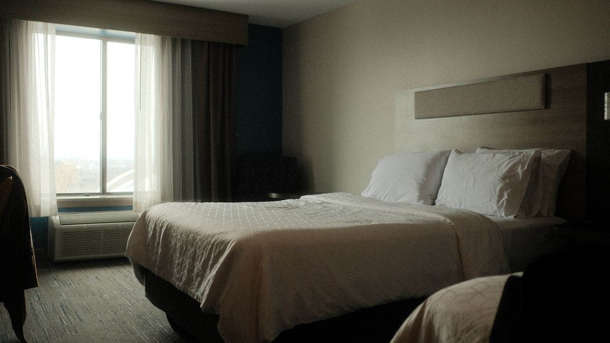 Inviting hotel room interior featuring a comfortable bed and soft morning light filtering through the window.