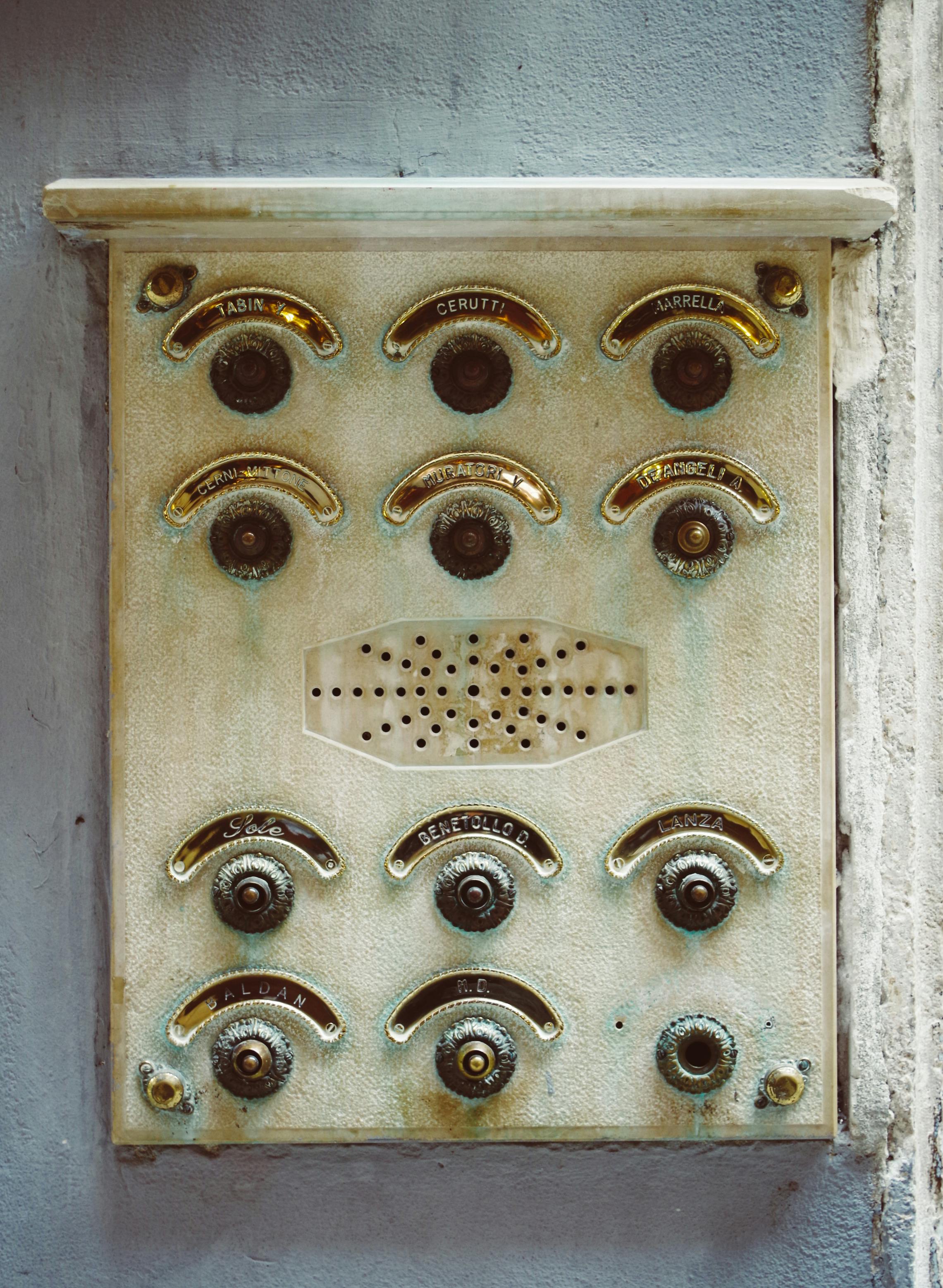 Free Rustic vintage apartment intercom panel with buttons and patina, evoking an old-world charm. Stock Photo