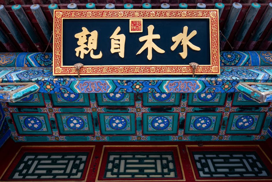 Detailed view of a traditional Chinese architectural sign with ornate designs and vibrant colors.