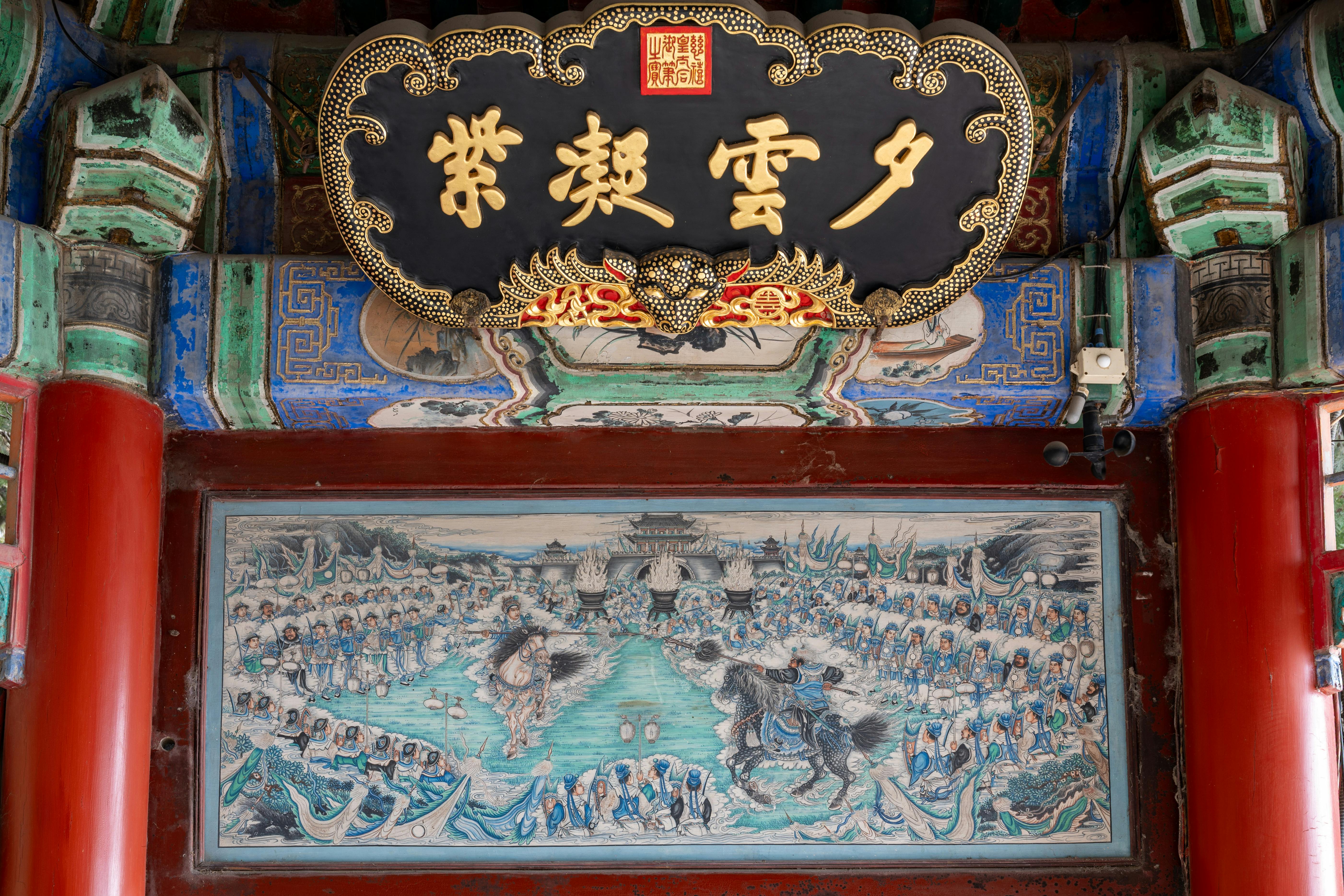 Intricate artwork and calligraphy adorn the ceiling of a historic Chinese temple.