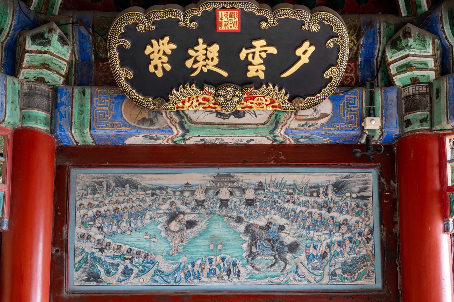 Intricate artwork and calligraphy adorn the ceiling of a historic Chinese temple.