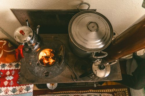 Free Warm rustic scene of a vintage stove with cooking pots and kettles indoors, exuding cozy vibes. Stock Photo