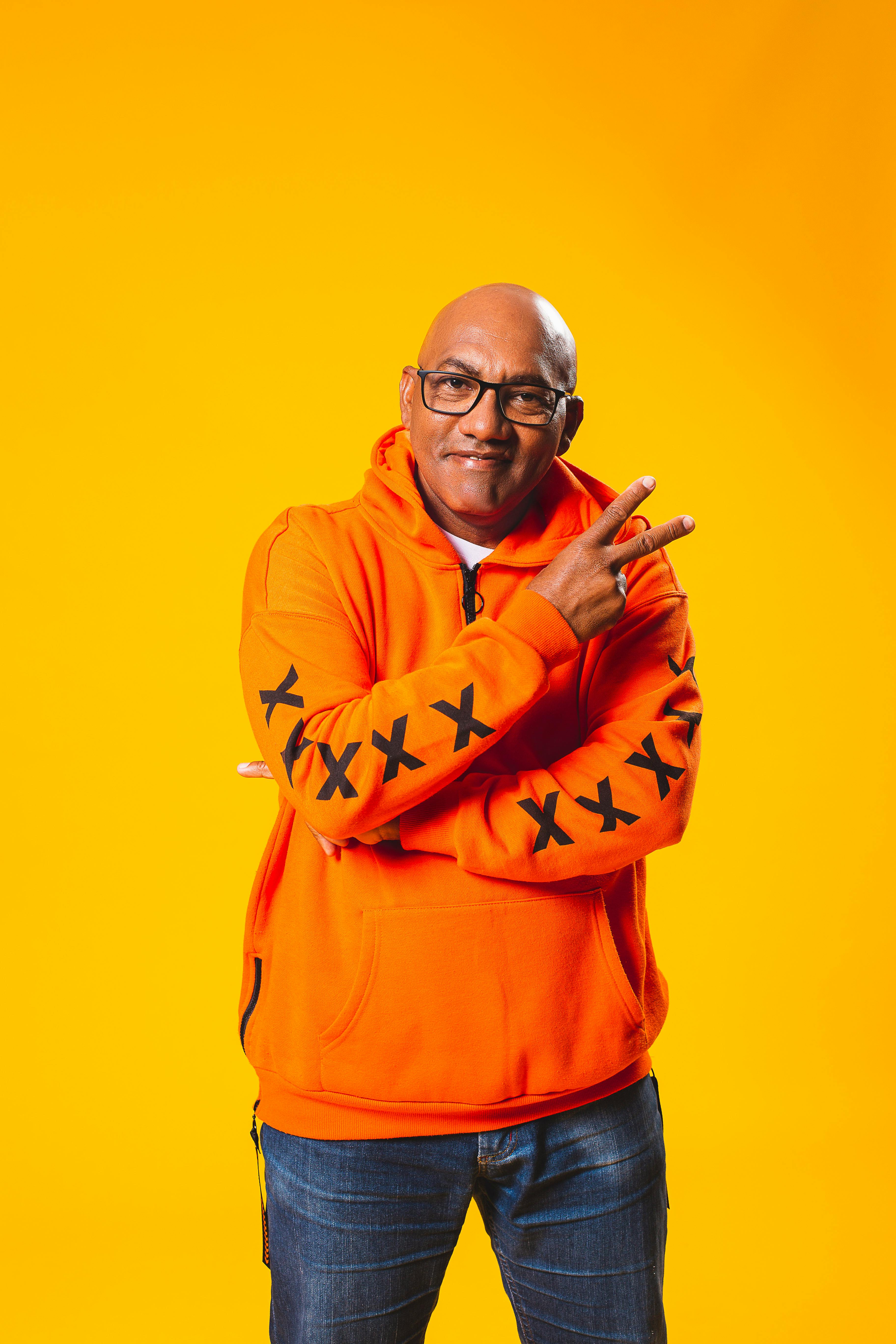 Man in Orange Hoodie Wearing Eyeglasses · Free Stock Photo