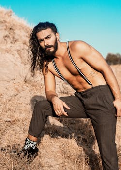 夏季，赤裸上身的男子穿着背带在户外摆姿势的肖像
