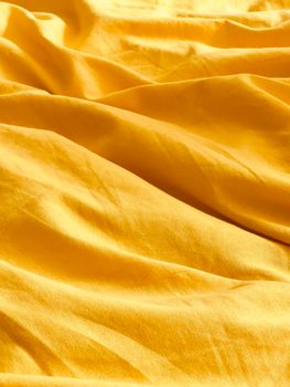 Bright yellow fabric with texture highlights perfect for design backgrounds and creative projects.