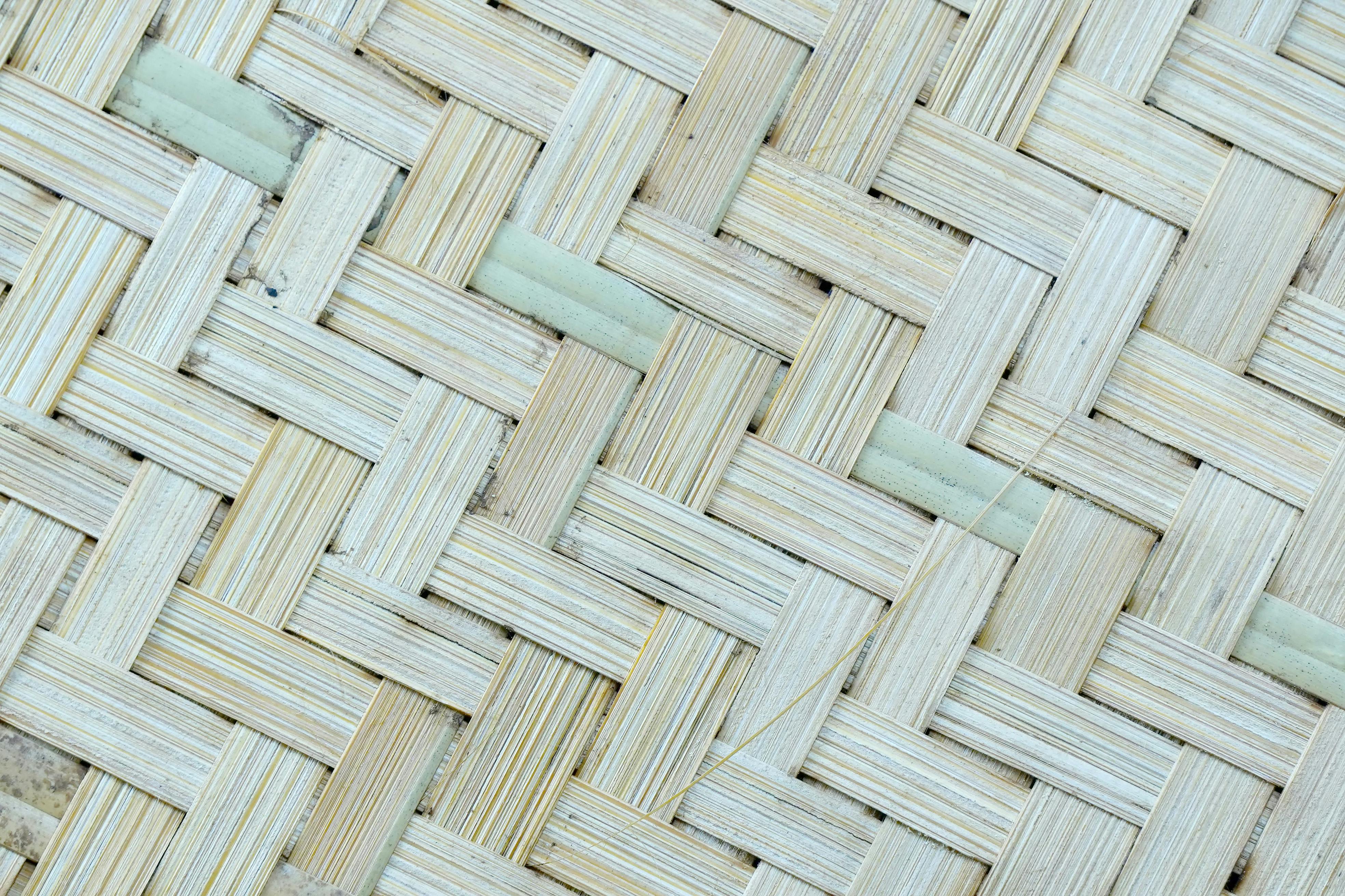 Gratis Detaljert nærbilde av en vevd bambustekstur som viser intrikat håndverk og naturlige farger. Arkivbilde