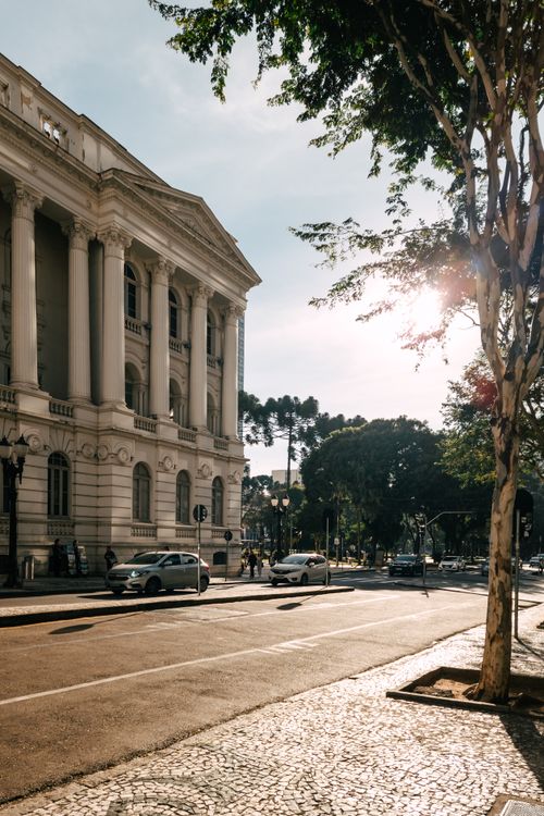 Free Stunning sunlit street scene in Curitiba, featuring classical architecture and vibrant city life. Stock Photo