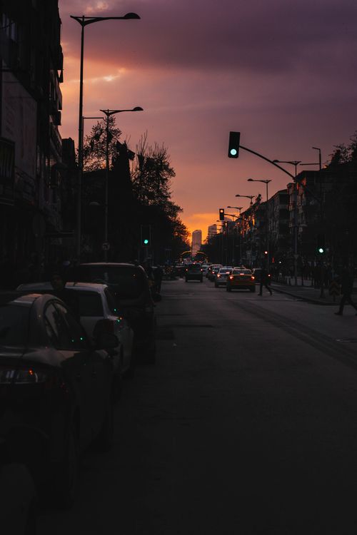 Free A bustling urban street with cars and silhouettes, captured beautifully at sunset. Stock Photo